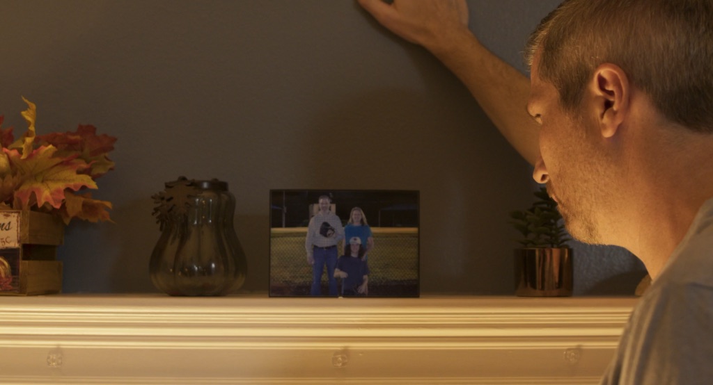 A man looking toward a family photograph in Memories of Diamonds